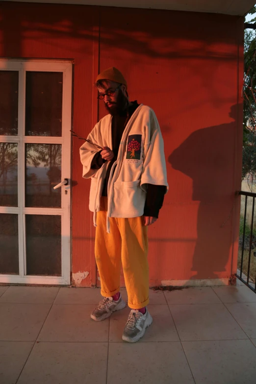 the young person is standing in front of a door wearing an all white jacket