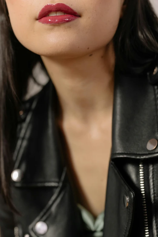 a woman with dark lipstick in a leather jacket