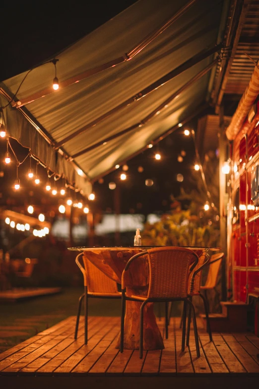 table with chairs under a roof at night