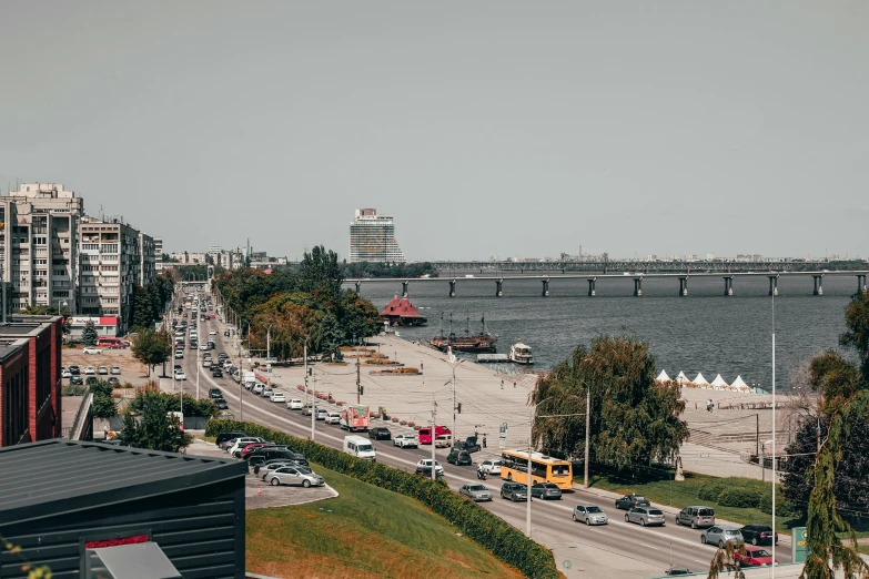 a city street filled with traffic next to a body of water