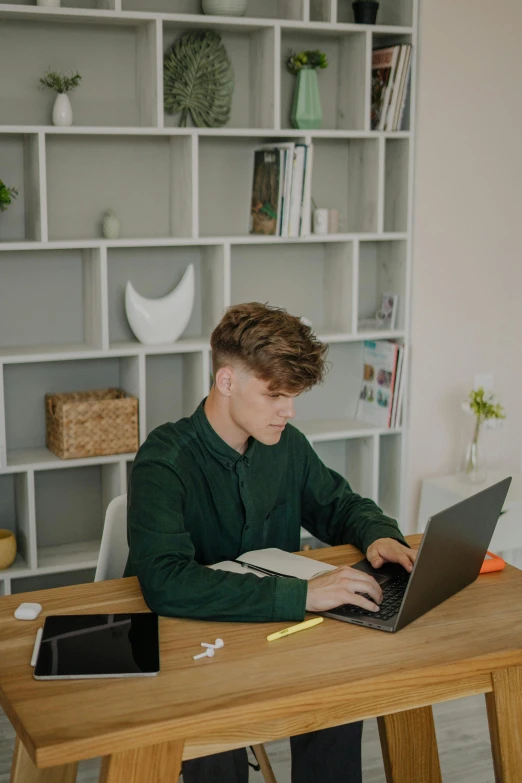 a man is sitting at a table on his laptop