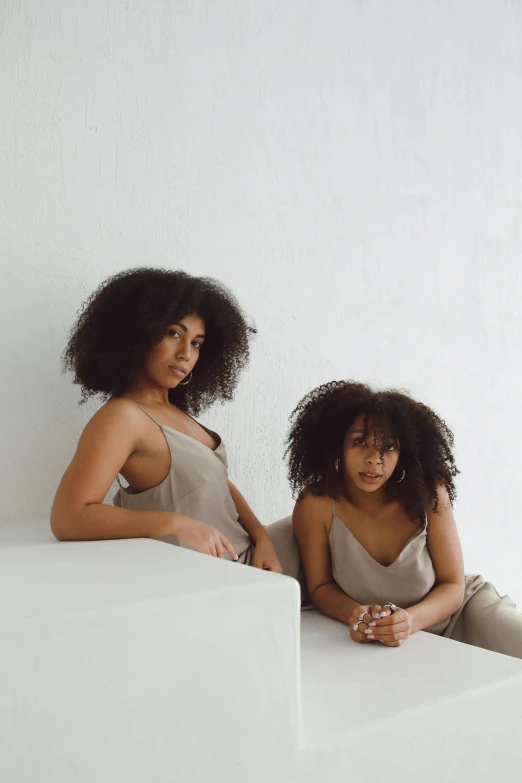 two women sitting down looking at the camera