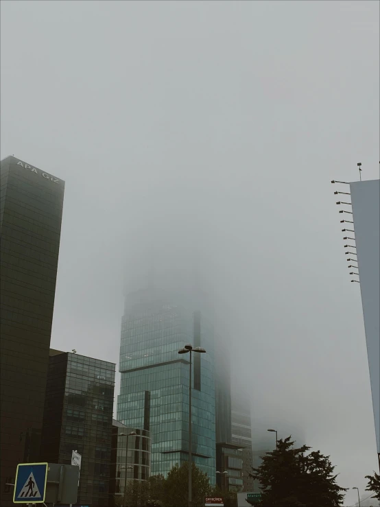 a tall skyscr sits in the middle of the fog