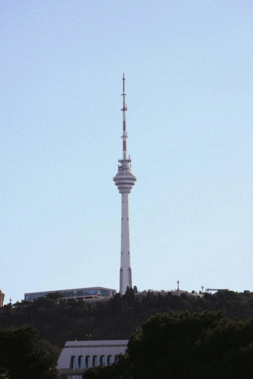 a large white tower sitting above trees in a city