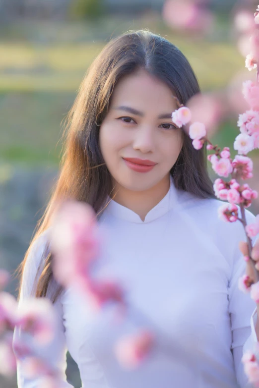 the woman in the white top is posing with flowers