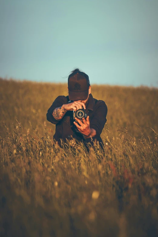 a person in a field taking a po with a camera