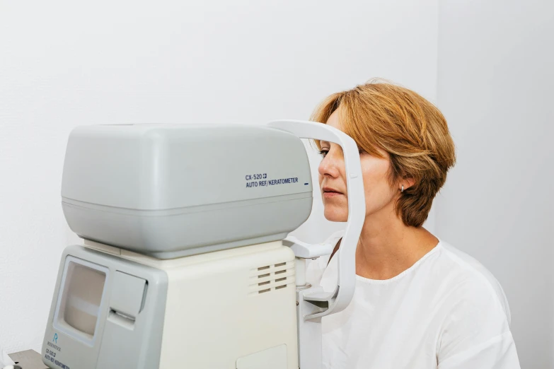 a woman is holding up her glasses to see how it fits in front of the camera