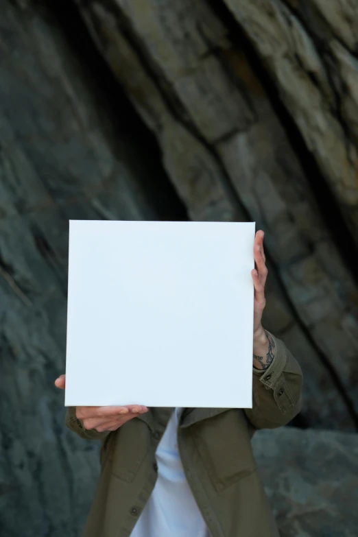 a person holding a paper in front of their face