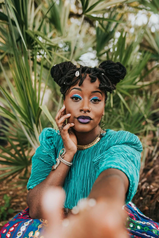 a woman in a turquoise shirt talking on a cellphone