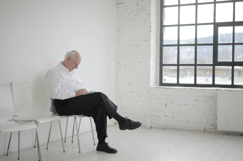 a man is sitting on a white chair