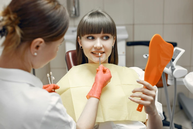 a young woman with orange hair brushes her teeth