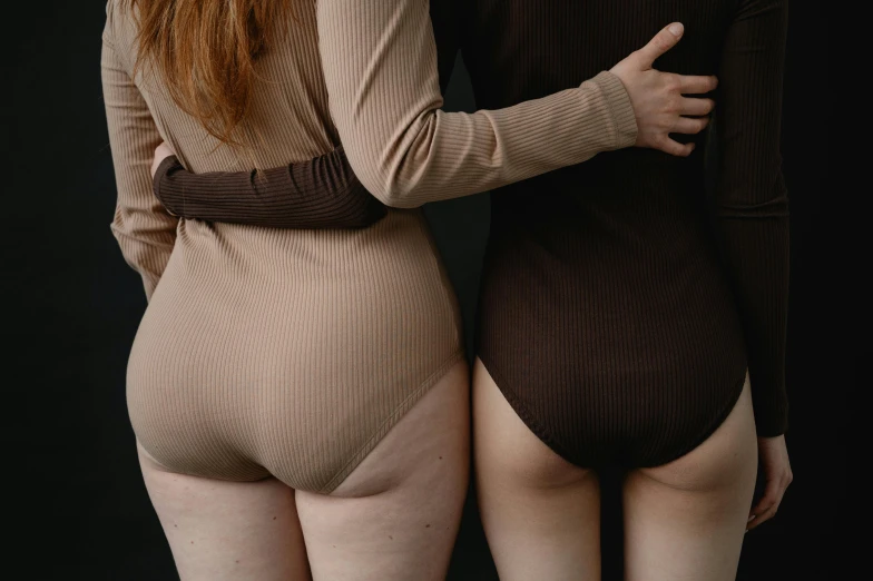 two women in tight bodysuits with long hair