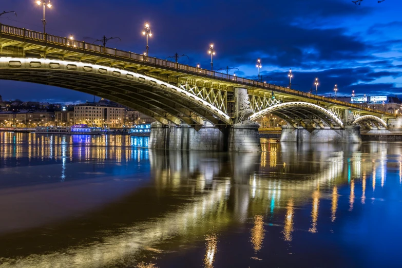 an elevated train over a bridge with night lighting