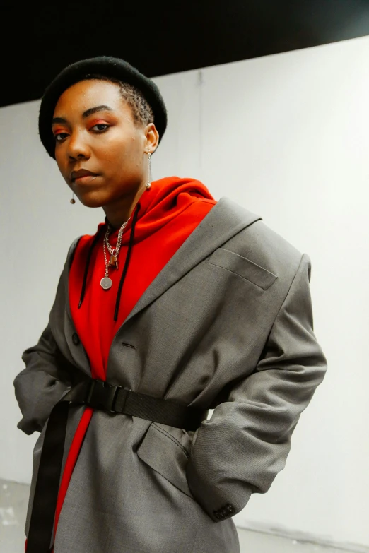 a woman in a red shirt standing on the sidewalk