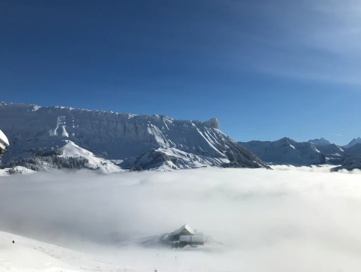 snowy landscape with clouds covering the mountain range