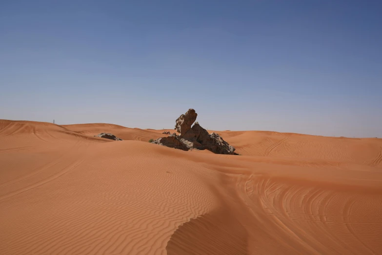 two large rocks sitting in the middle of an open desert