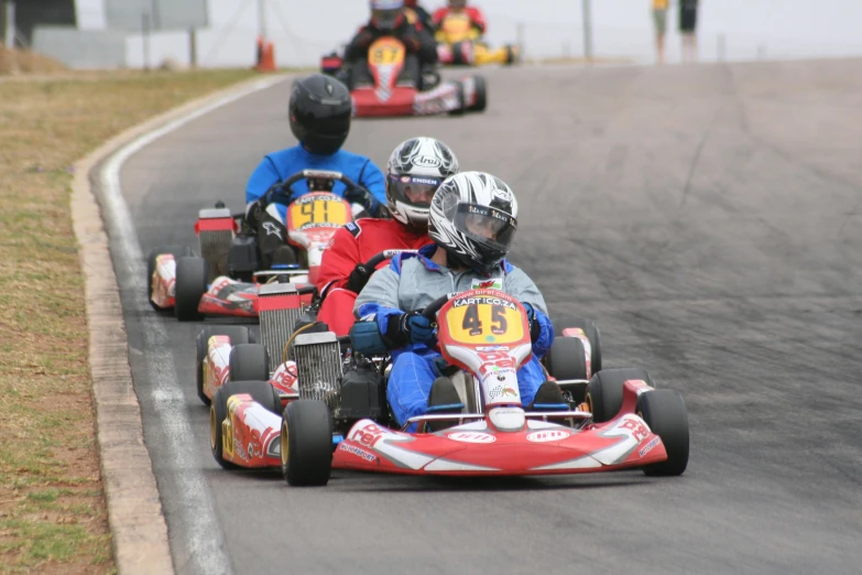three people are in a go kart driving contest