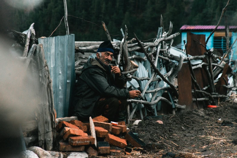 a man sitting on a pile of wood