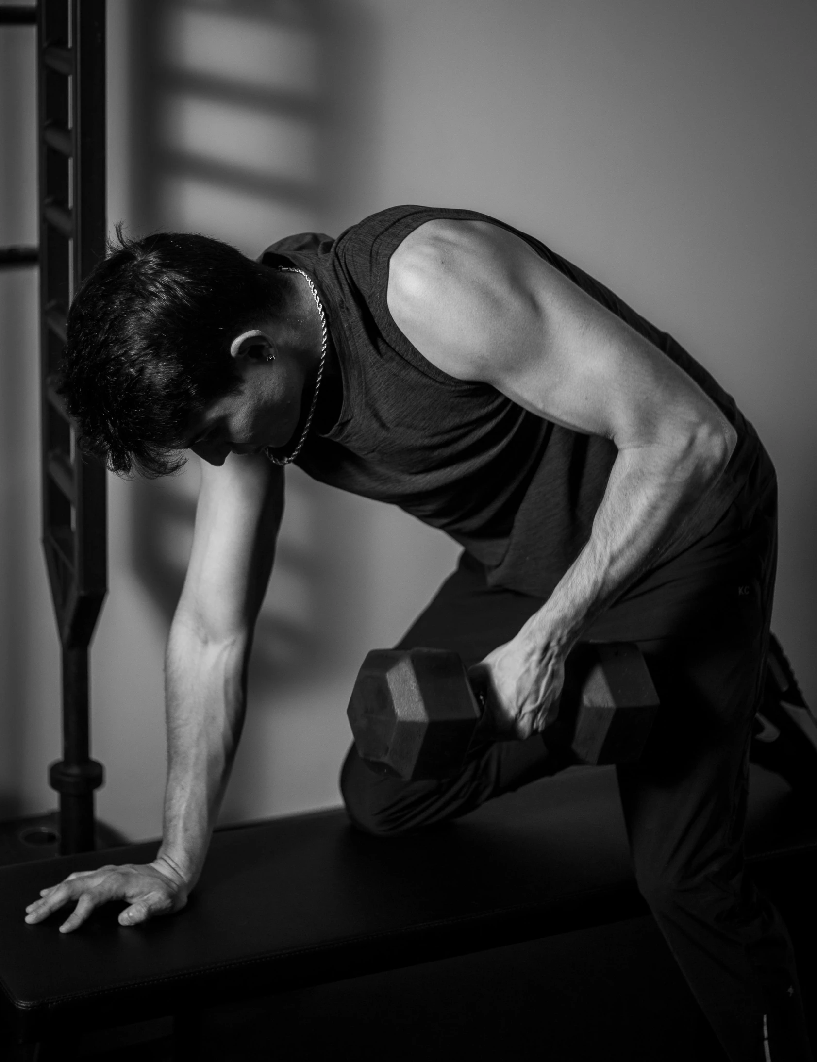 a man kneeling down while holding a dumb bar