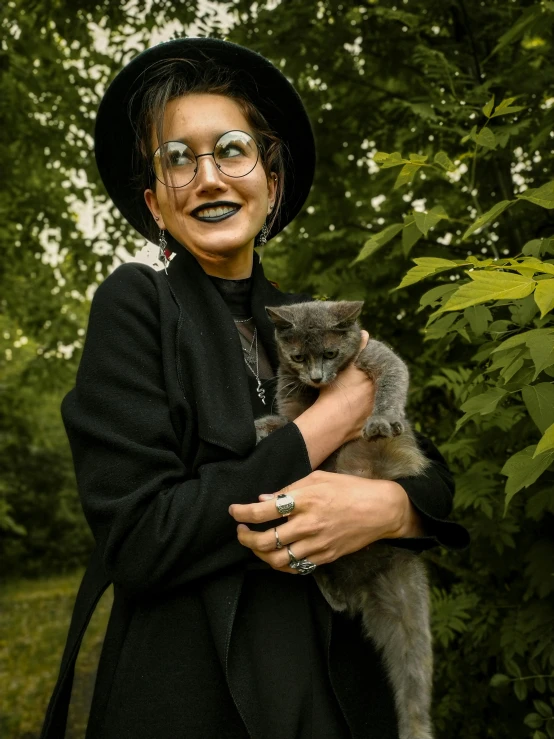 a woman in a cat costume and hat holding a cat