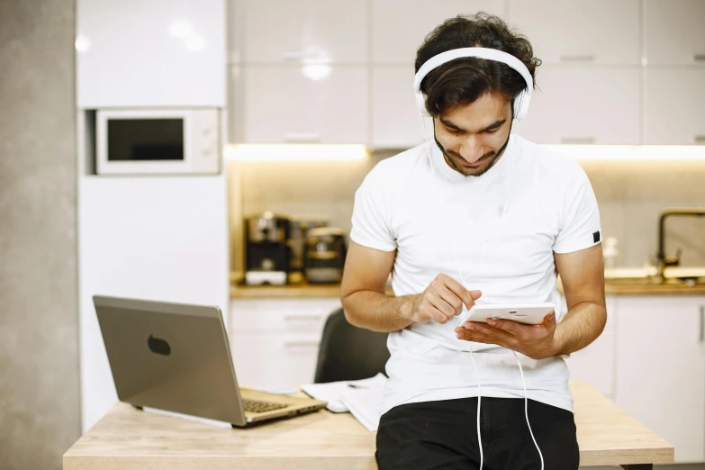 a man is looking at a smartphone and earphones