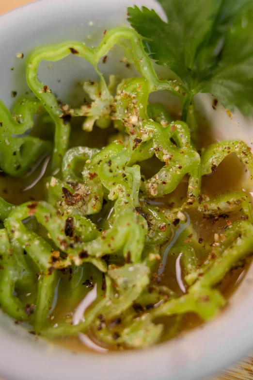 a bowl of green soup with a little bit of sprig on top