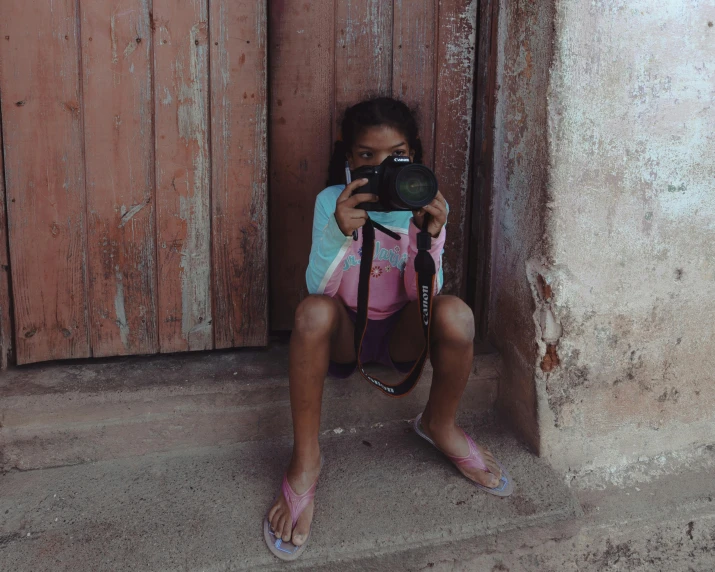 a little girl that is holding a camera