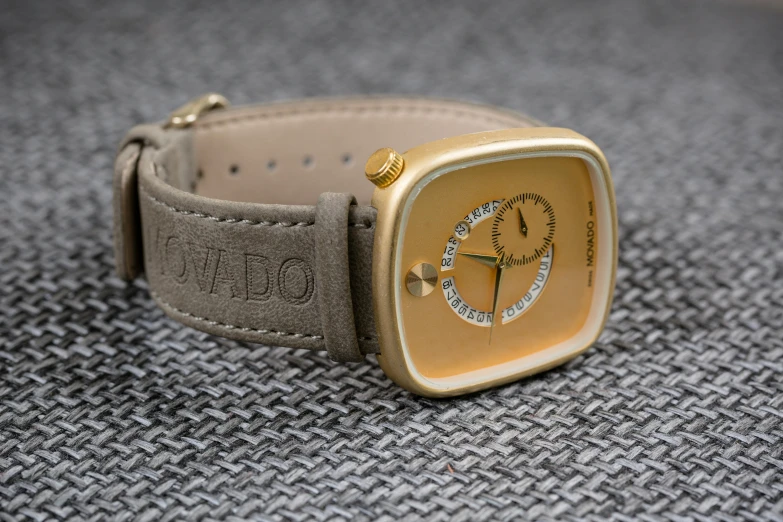 a wrist watch has gold and a black arrow