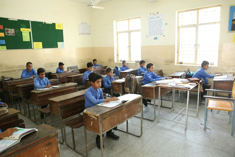 a classroom full of desks with children sitting at them