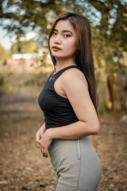 an asian woman poses for a po in a park