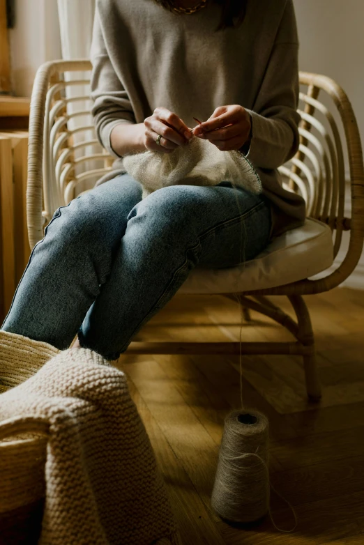 a woman is knitting while holding her cat