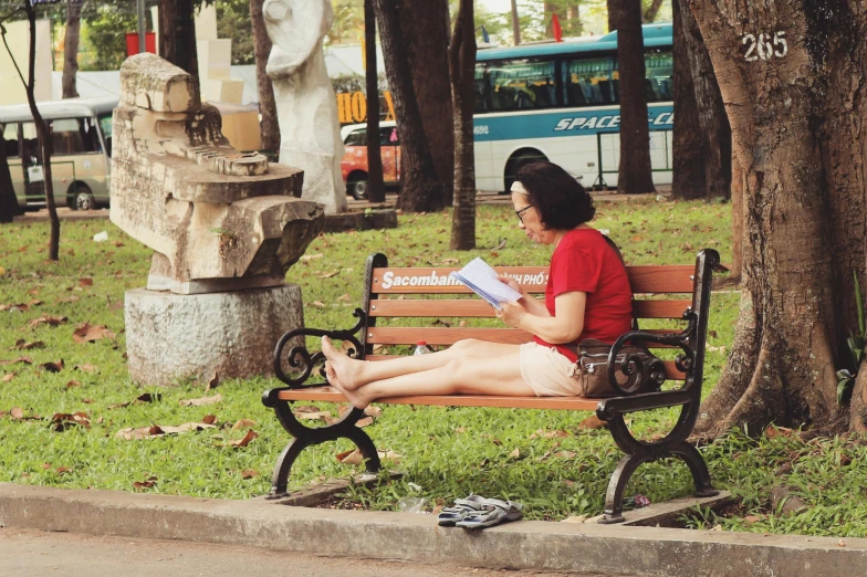 a woman sitting on a bench near a fountain