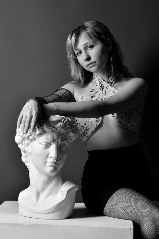 black and white pograph of woman fixing a bust