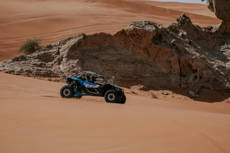 man drives buggy through desert landscape in desert setting