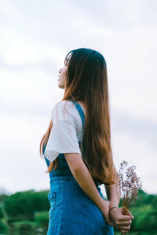 a woman holding a flower behind her back