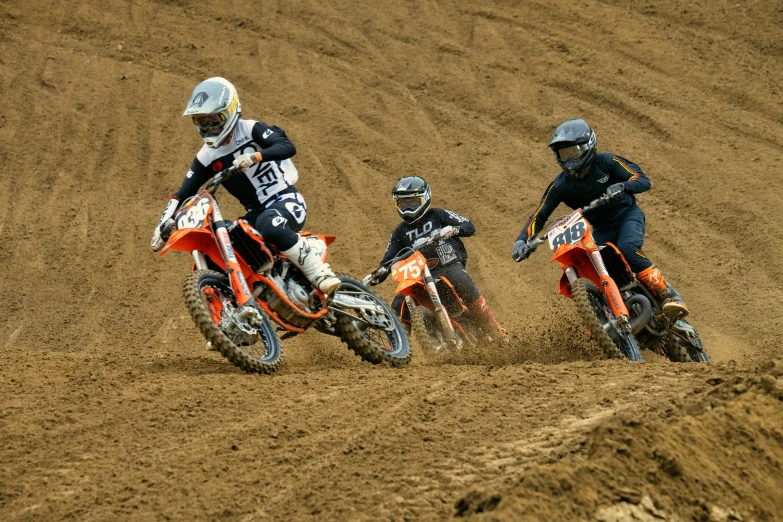 there are three men riding motorcycles in the dirt