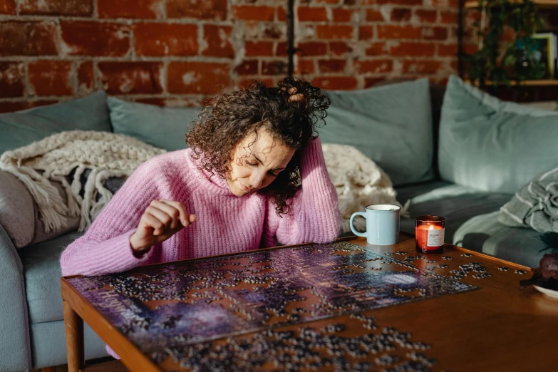 a young woman sitting in front of a table with a cup