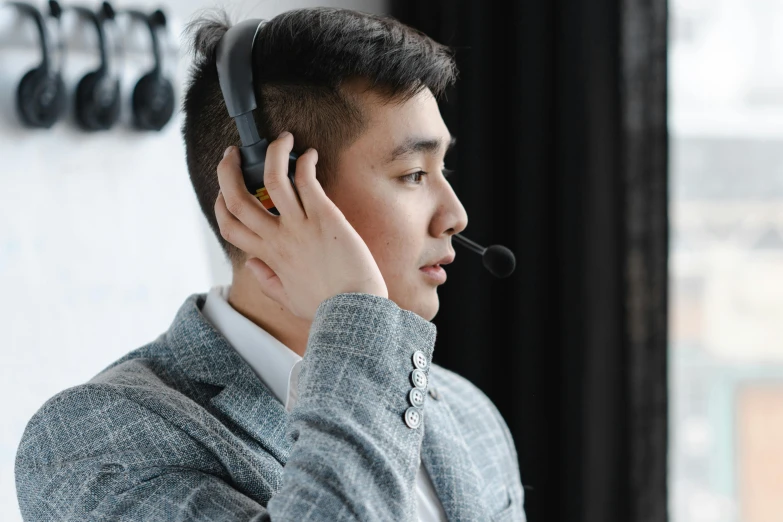 a man holding a headset in his hand near the wall