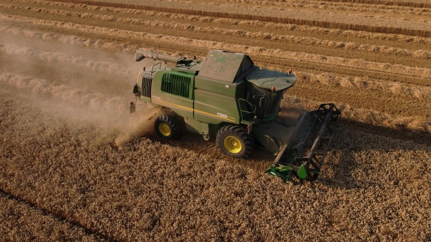 a green harvesting vehicle is working in a field