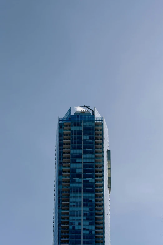 a very tall building with many windows next to a cloudy sky