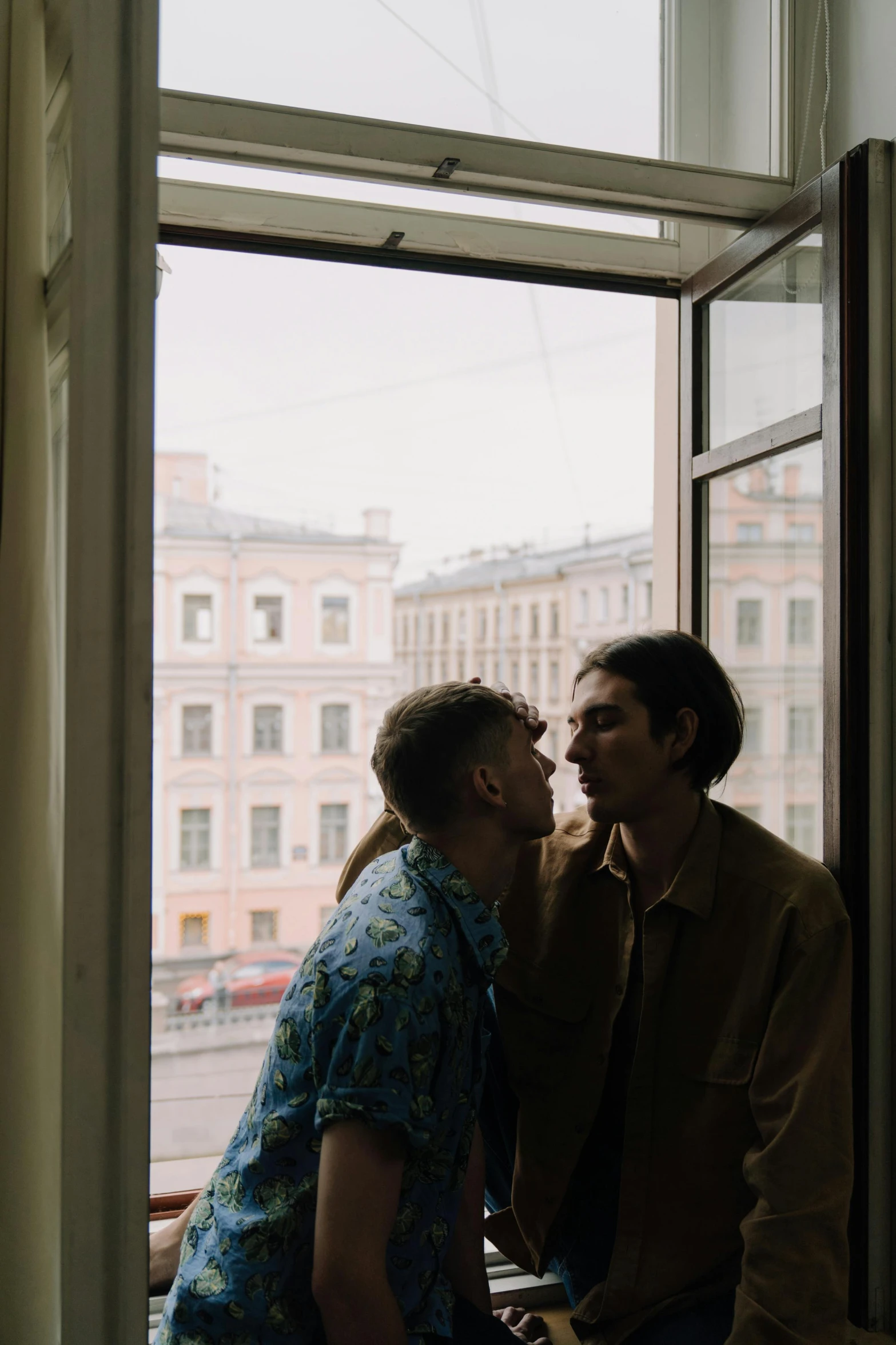 two men sharing a laugh with each other near a window