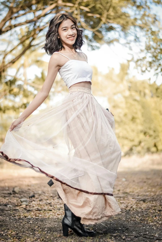 a beautiful young asian woman in a white top and a beige skirt poses with her feet spread out
