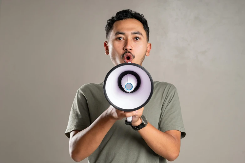 a man holds an open megaphone up in his hand