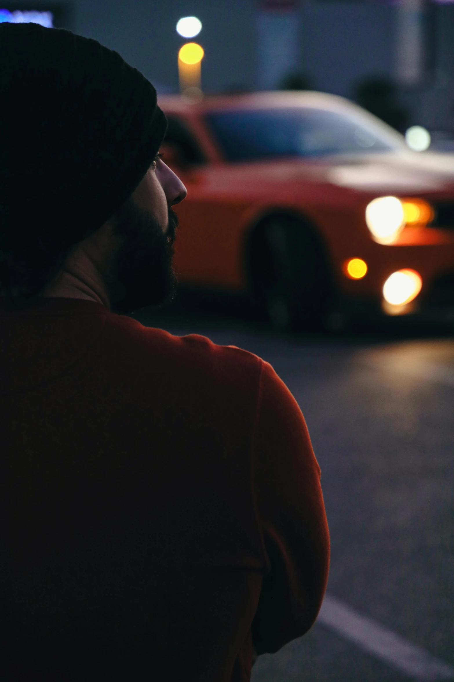 a person wearing a beanie is staring at a car