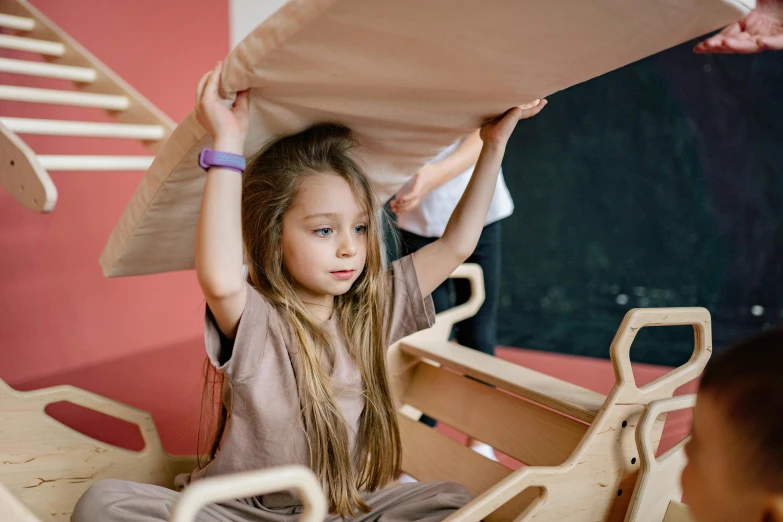 a girl holds up a pillow over her head