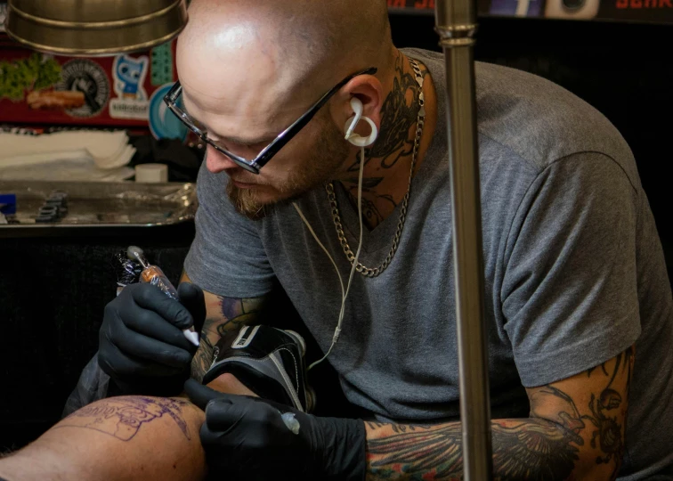 a man with some tattoos on his arm is getting a tattoo