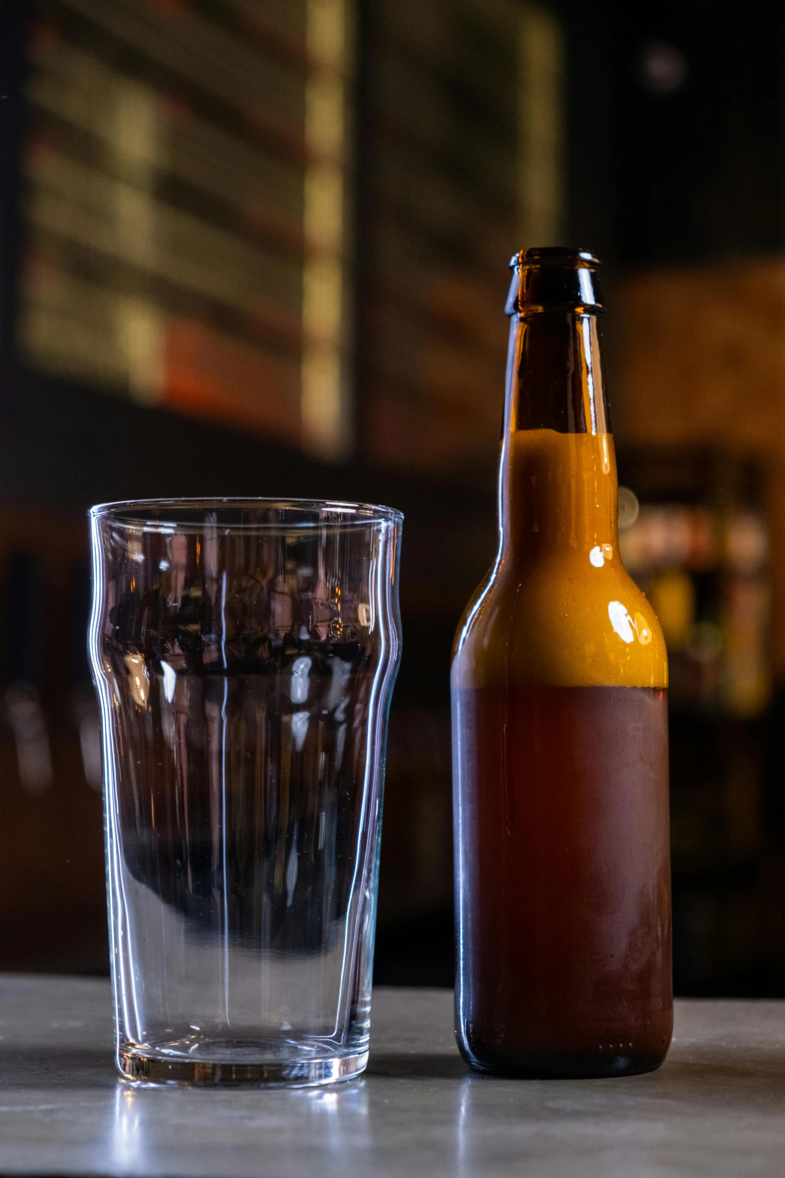 a glass on the table next to a beer