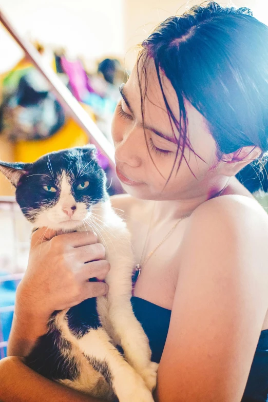 the girl is holding a cat with very small eyes