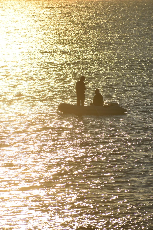 two people are standing in a row boat in the water
