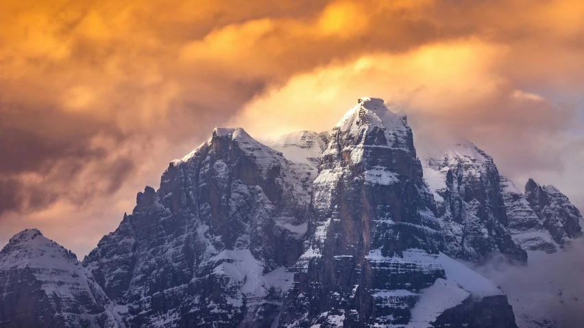 the large mountain range covered in clouds on a cloudy day